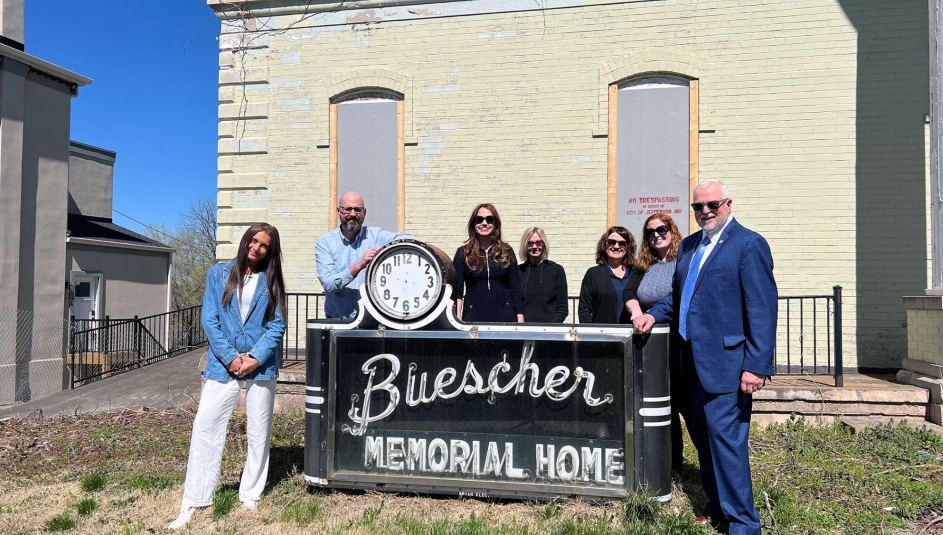 Staff of the Missouri Association of Counties stand in front of the historic “Buescher Memorial Home” sign located at 429 Capitol Ave. in Jefferson City. From left: Intern Isabella Grander, Deputy Director David Owen, Member Engagement Director Carah Bright, Finance and Operations Manager Cindy Wells, Administrative Support Assistant Charlotte Onstott, Event and Marketing Coordinator Meredith Melahn and Executive Director Steve Hobbs. Not pictured due to traveling: Trust Risk Manager Sean McGonigle