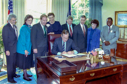 President George H.W. Bush signs a proclamation March 19, 1991 establishing National County Government Week. Looking on are: John Thomas, NACo executive director; Ann Klinger, NACo immediate past president; Michael Steward, NACo president; Kaye Braaten, NACo first vice president; Sen. Conrad Burns (R-Mont.) and Rep. Ben Erdreich (D-Ala.), who introduced the measure in Congress; Barbara Sheen Todd, NACo third vice president and John Stroger, NACo second vice president. Photo by David Hathcox